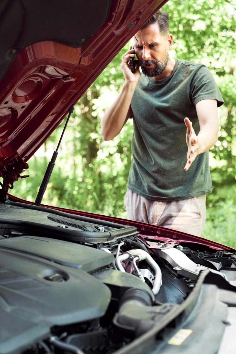 Junger Mann prüft Getriebeschaden bei Schrottauto Ankauf Kamen